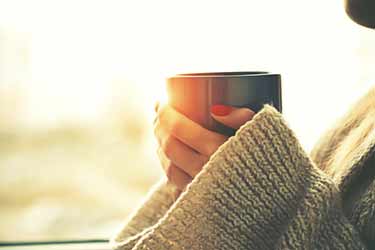 holding mug of coffee