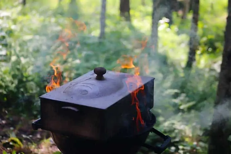 wood and charcoal smoking of fish in a cast iron smoker