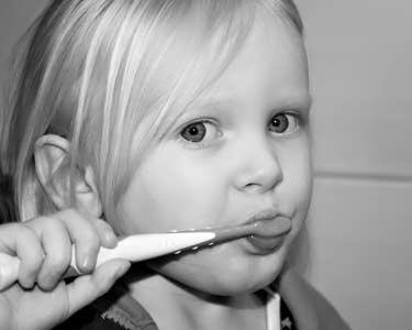 female child brushing teeth