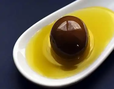 whole olive sitting in olive oil