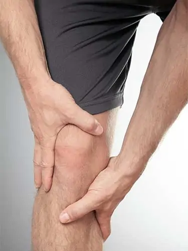 man holding knee in pain