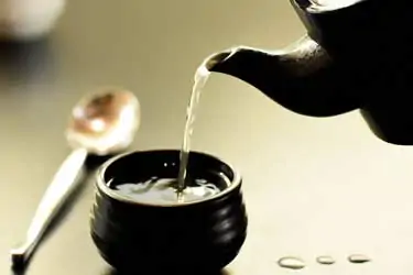 pouring hot water into tea cup